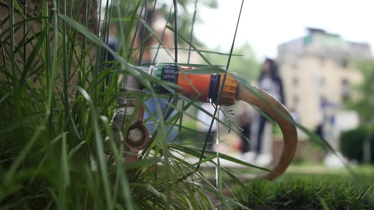 Close-up of a water leak in a municipal watering system through a ball joint on a watering hose. A jet of water leaks from a poor-quality water connection for watering the lawn. loss of fresh water