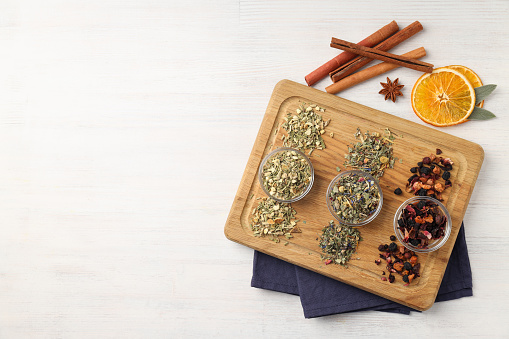 Concept of cooking tea with different types of tea on white wooden background