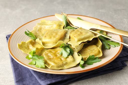 Delicious food concept with ravioli on gray background