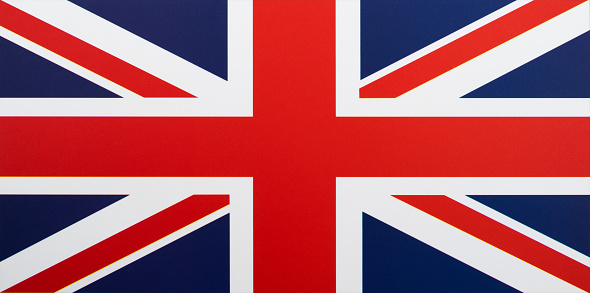 Flag of United Kingdom on a wooden table background. Wrinkled British flag top view.
