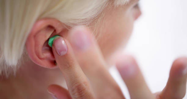 istock Woman Putting Earplug Into Her Ear 1495275832