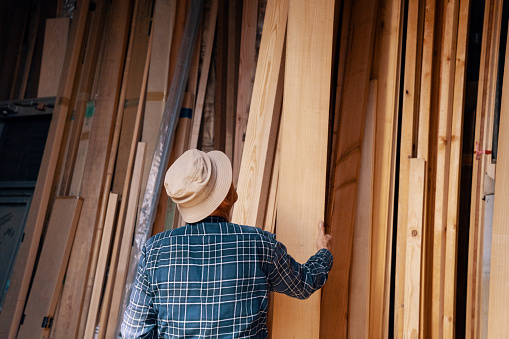 Senior carpenter selecting a piece of wood in his workshop