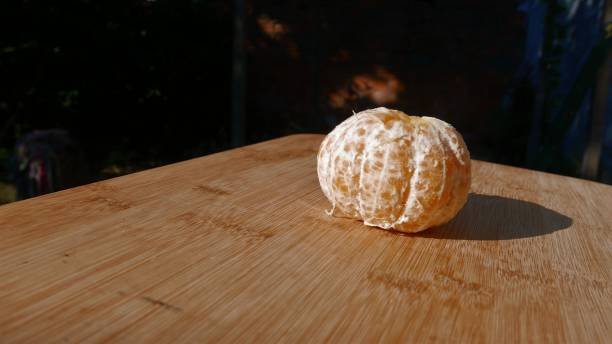 Citrus fruits. Healthy eating. A ripe tangerine ready to eat. Fresh tangerine. An open tangerine on a table. Fresh fruits on the table. Tangerine close-up, side view. Ponkan on the table. Ponkan tangerine. Tangerine (citrus reticulata). This fruit is also known as (bergamot). Eating fruits. Mandarines and tangerines. Peeled fruits. una gran mandarina madura, primer plano. una mandarina pelada sobre la mesa. frutas maduras en la mesa. una gran mandarina fresca al sol. comer fruta fresca al aire libre. ponkan mandarina, vista de cerca. fruta madura. mandarinas ponkan