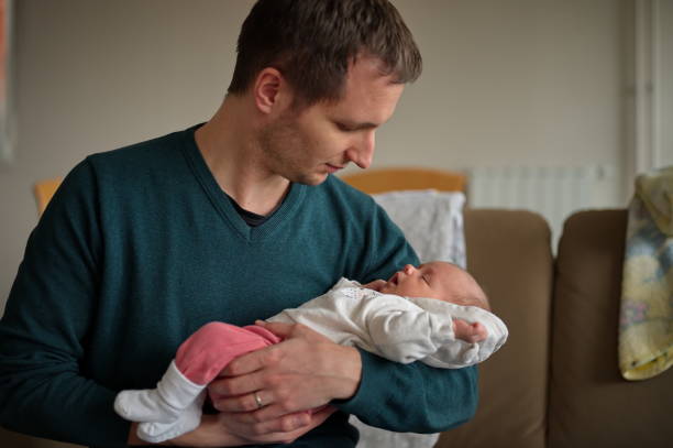 istock Man holding newborn baby 1495277294