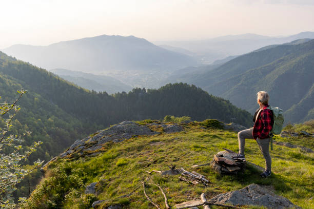 Senior man hikes up mountain ridge