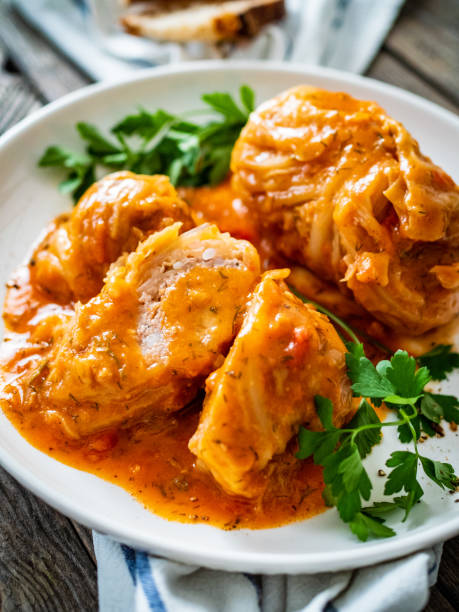 istock Wrapped meat cabbage leaf with tomato sauce on wooden table 1495283738