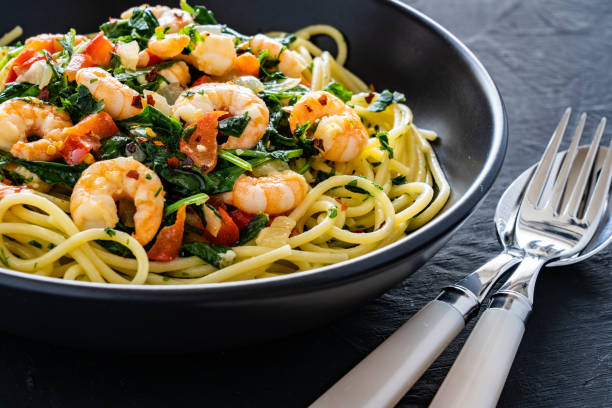 istock Spaghetti with prawns and stir-fried vegetables on black background 1495284747