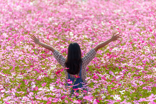 Happy woman raiseก open arms arms at flower garden in Chiang Mai, lifestyle and healthy confidence relax woman concept.