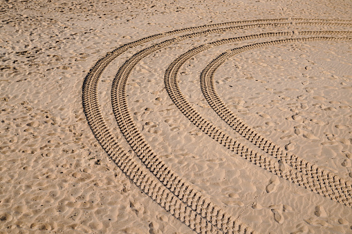 wheels tracks wheel tires on the fine sand of the desert beach on dust dune