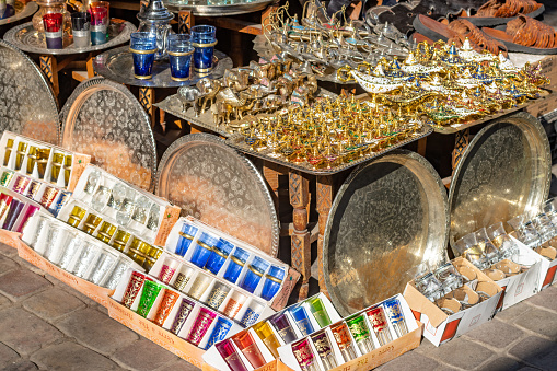 Many souvenirs for sale at Market Stall in Souk at Medina District of Marrakesh, Morocco. Design elements are visible.
