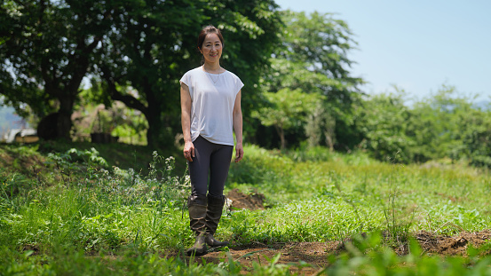 A portrait of a female farmer in a farming field.