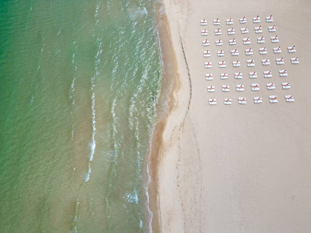 istock A sandy beach stretches along the seaside, adorned with empty sun loungers. Aerial view 1495290779