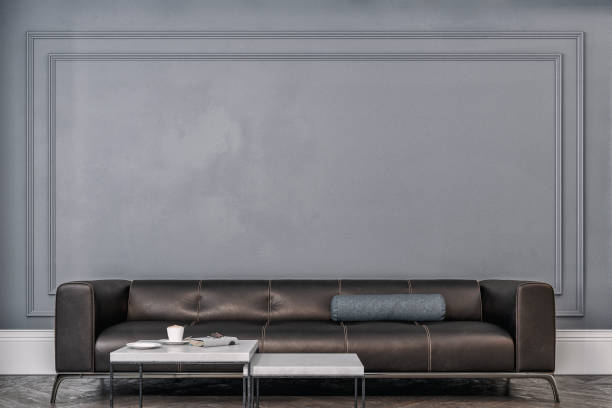 istock Cozy retro-chic interior with a black leather cushion sofa, paneled wall with moldings, 50s- 60s decoration 1495291098