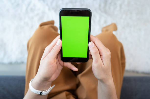 istock Cropped shot of woman using or texting chat on mobile phone with green screen. 1495296056