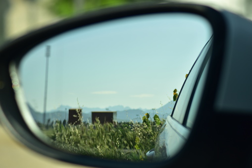 Side view mirror crop field and mountains view