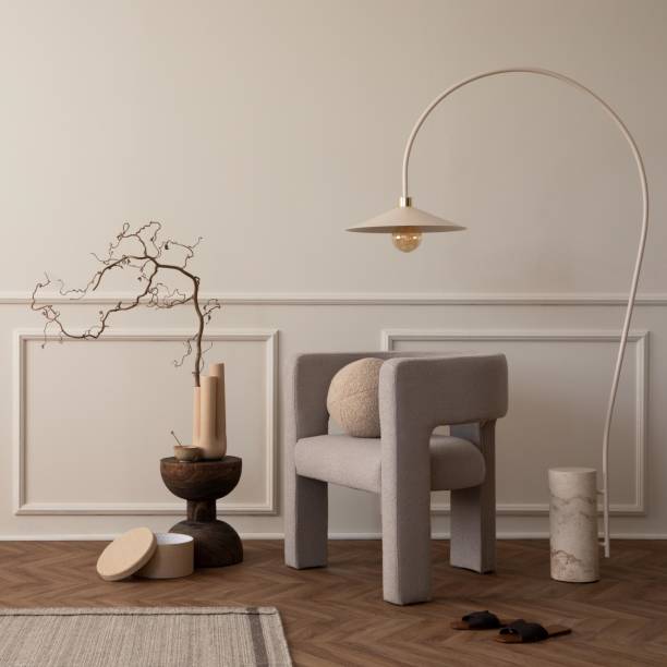 Creative composition of living room interior with copy space, modern armchair, round pillow, lamp, wooden coffee table, pouf, gray rug, vase with branch and personal accessories. Home decor. Template. composición creativa del interior de la sala de estar con espacio de copia, sillón moderno, almohada redonda, lámpara, mesa de centro de madera, puf, alfombra gris, jarrón con rama y accesorios personales. decoración del hogar. plantilla.