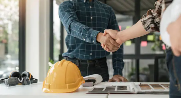 Photo of Engineer and contractor shaking hands success of the project work together