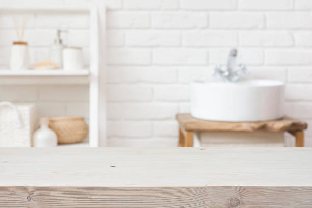 istock Empty wooden table and blurred view of bathroom sink interior 1495311782
