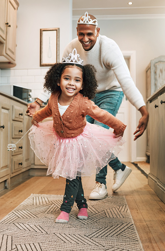 Child tutu, ballet dance and portrait of girl and father together bonding with dancing in the kitchen. Home, kid and dad with parent love and care in a house playing a dancer game for children fun