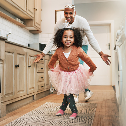 Child, ballet dance and portrait of a girl and father together bonding with dancing in the kitchen. Home, kid and dad with parent love and care in a house playing a dancer game for children fun