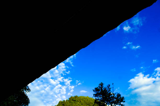 istock Low Angle View of a tranquil nature scene with a black shadow triangle frame, blue sky, and clouds 1495314416