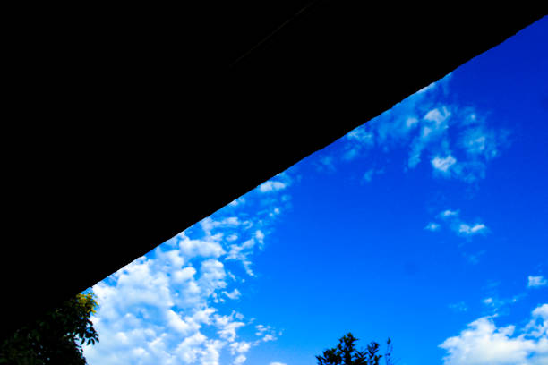 istock Low Angle View of a tranquil nature scene with a black shadow triangle frame, blue sky, and clouds 1495314805