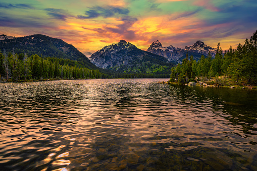 Sunset over Taggart Lake and Grand Teton Mountains in Wyoming, USA. Taggart Lake is a stunning alpine lake in Grand Teton National Park, surrounded by majestic mountains.