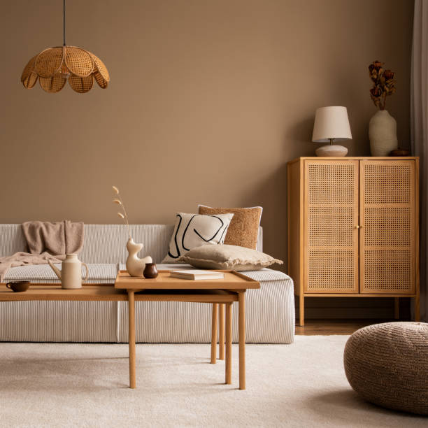 istock Creative composition of living room interior with modular sofa, wooden coffee table, rattan sideboard, beige rug, pillows and personal accessories. Home decor. Template. 1495317896