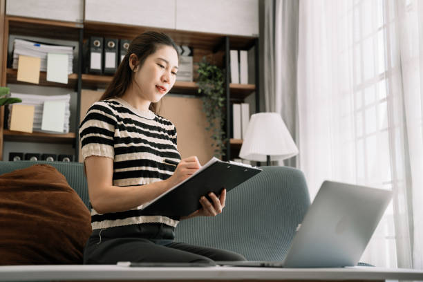 istock Female writes information businessman working on laptop computer writing business plan while sitting in home office. 1495320340