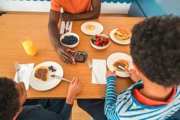 istock Father and Two Sons Enjoying Pancakes and Fresh Fruit 1495320585