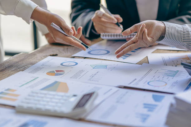 istock Meet with colleagues to discuss sales analysis in financial reports with graph papers. Financial accounting and business strategy planning related to sales analysis in company marketing reports. 1495320731
