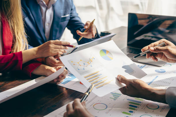 istock Meet with colleagues to discuss sales analysis in financial reports with graph papers. Financial accounting and business strategy planning related to sales analysis in company marketing reports. 1495320752