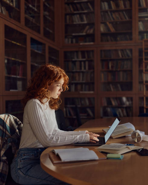 istock Teenage female student e-learning over laptop in library. 1495320792