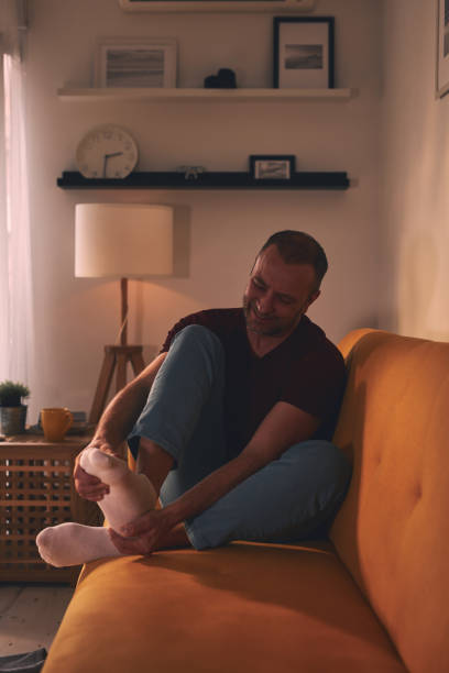 istock Man with foot pain at home. 1495320962