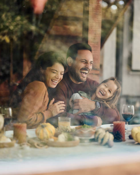istock Cheerful parents having fun with their daughter at dining table. 1495322316