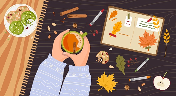 Cozy Autumn. Person Hands holding hot spicy drink. Wooden table with creative notebook, cookies, red leaves. Autumn flat lay, top view illustration for Fall mood poster, postcard, flyer template
