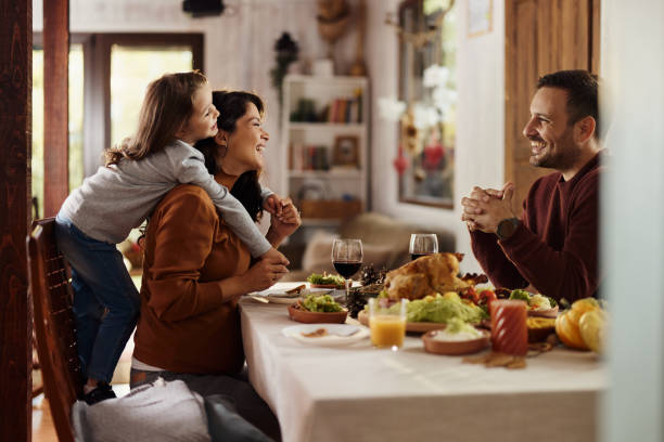 istock Happy mother and daughter talking to a father at dining table. 1495323145