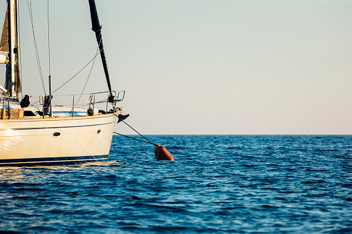 Sailboat tethered to anchor buoy at island Palagruza, Dalmatia, Croatia.