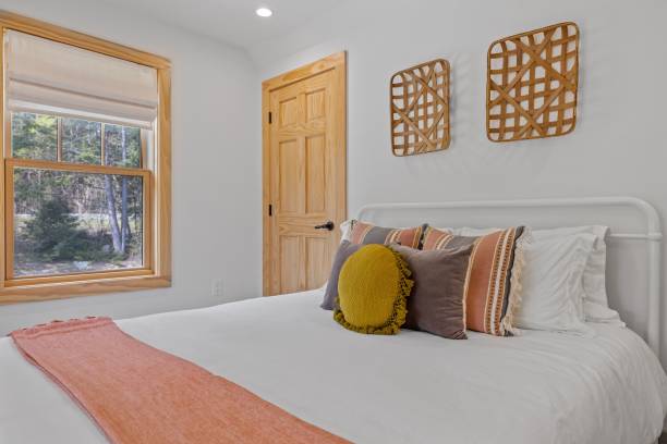 istock Made bed in a cozy bedroom featuring a set of decorative pillows on top 1495324974