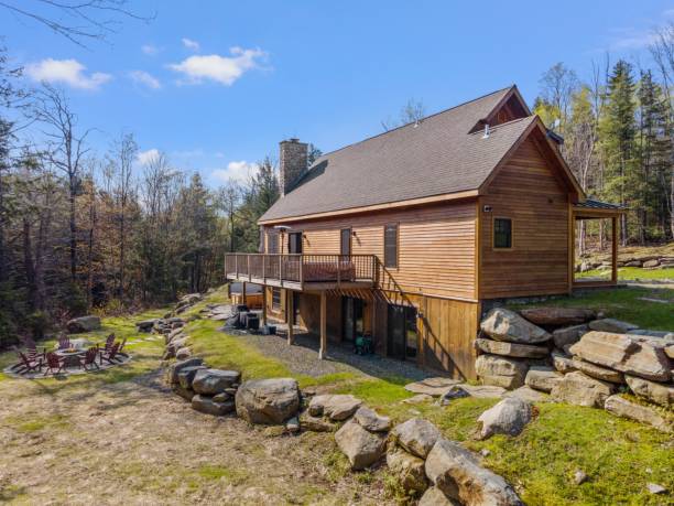 istock Picturesque log cabin perched in a tranquil forest, surrounded by lush greenery and rugged rocks 1495324983