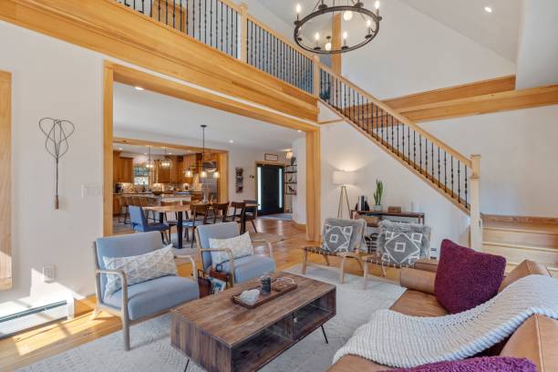 istock Modern living room interior, with a beige couch and two armchairs situated underneath a staircase 1495325041