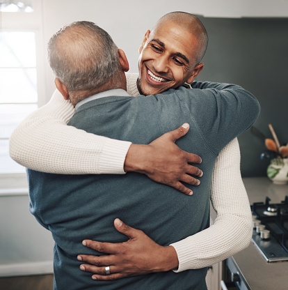Family, hug or son with senior father for Fathers Day love, home bond or embrace in modern kitchen. Smile, happiness or support care from Mexico dad, papa or man in emotional reunion with male in law