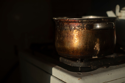 Rusty pot in kitchen. Old dishes. Kitchen details. Light on metal.