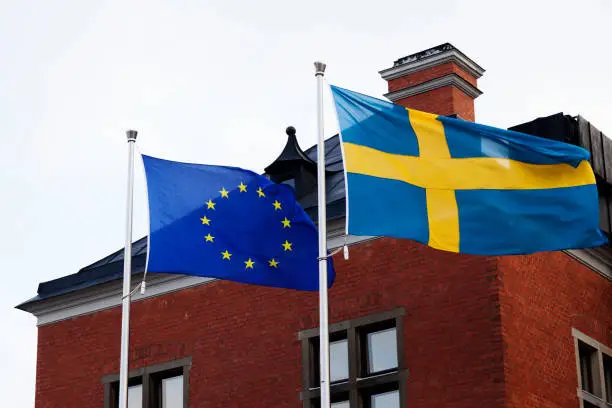the Swedish and European flag waving in the wind together, the EU summit in progress