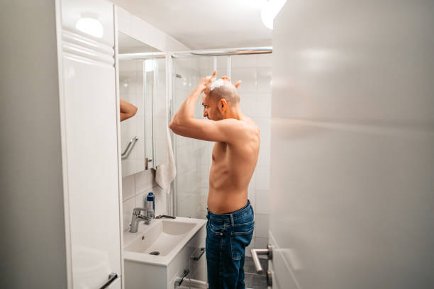 istock Young Man Shaving His Head In The Bathroom 1495339762