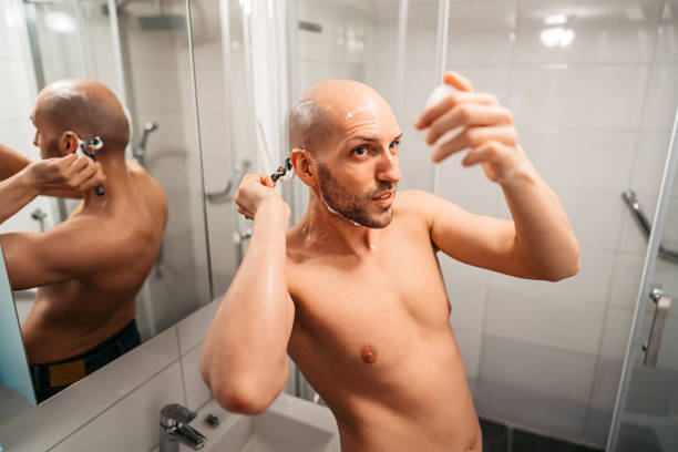 istock Young Man Shaving His Head In The Bathroom 1495340879