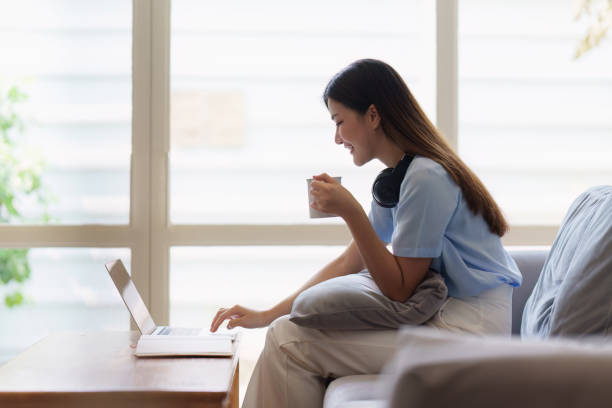istock Attractive Asian woman resting comfortable living room and using laptop computer, Relax, Sofa, Lifestyle 1495342658