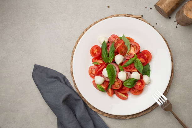 istock Salad with tomatoes, mozzarella and basil on a gray background 1495342890