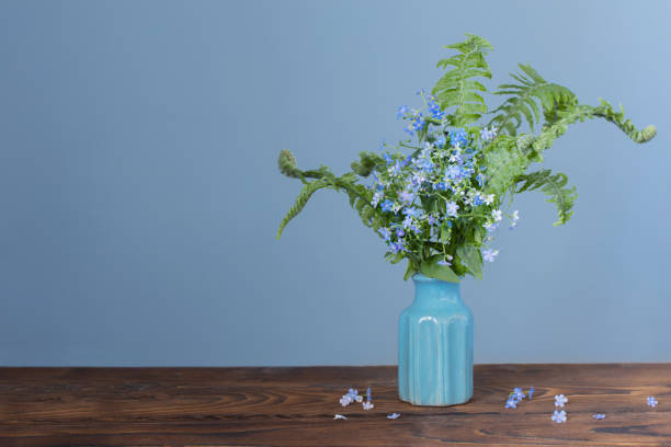 istock wild flowers in vase on background blue wall 1495344823