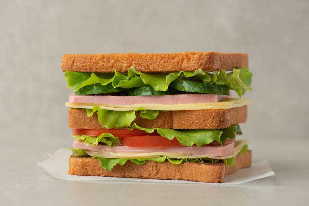 istock Sandwich with mortadella, cheese and tomatoes on a gray table 1495345162